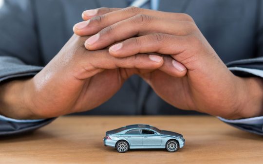 businessman-protecting-toy-car-with-hands-2021-08-28-17-56-30-utc (1)